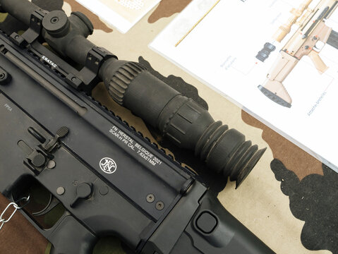 Paris, France - Sep 14, 2025: Closeup of FN Herstal SCAR-H PR tactical rifle in black finish equipped with scope, ERATAC mount and manual, military firearm concept