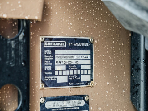Paris, France - Sep 14, 2025: Closeup of Soframe manufacturer and Jige International identification plate on military vehicle with raindrops, heavy polyvalent recovery truck