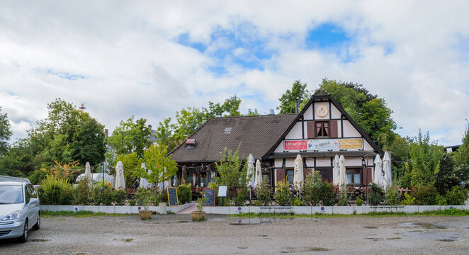 Strasbourg, France - Sep 14, 2025: Front view of Restaurant Le Mannele featuring Alsatian architecture, summer terrace with outdoor tables, lush greenery and welcoming atmosphere