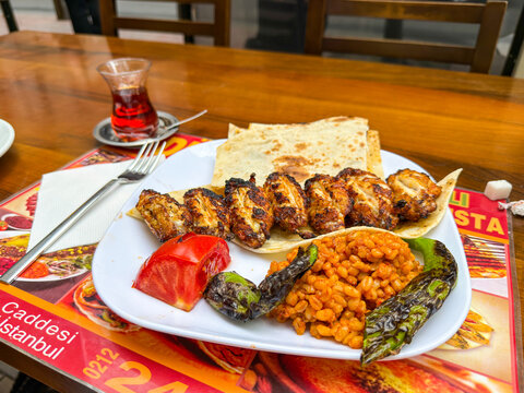 Istanbul, Turkey - August 29, 2025: Traditional Turkish Tavuk Kanat served with bulgur, grilled vegetables and lavash in a local restaurant