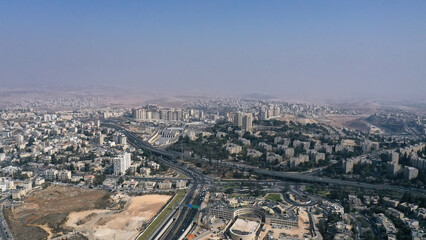 Fototapeta premium Northern Jerusalem aerial viewA wide drone shot overlooking northern Jerusalem with residential neighborhoods, highways, and distant desert hills on the horizon.