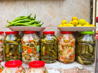 Traditional Turkish pickled vegetables in glass jars with green peppers and lemons arranged on top showing authentic culinary culture