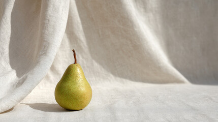 fresh ripe pear rests elegantly against backdrop of soft linen fabric illuminated by ultrabright sunlight