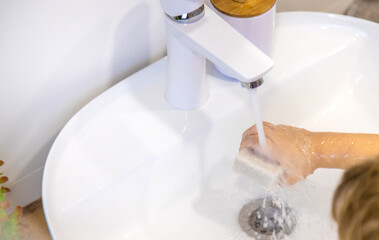 The child washes his hands with soap. Selective focus.