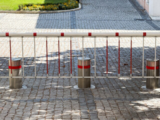 Stainless steel traffic bollards and safety barrier on cobblestone street in urban public area