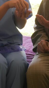 Female doctor helps ederly patient in hospital. Vertical Video