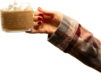 Hand offering patterned glass mug with whipped cream in flannel sleeve on transparent background. Concept of relaxed winter lifestyle, warm drink advertising, and comforting seasonal mood.