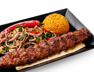 Grilled kebab served with spicy rice and fresh salad on a black plate