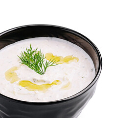 Creamy dip with fresh herbs served in a black bowl for a delicious snack