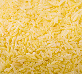 Yellow rice filling a surface, showcasing its texture and color in close-up view