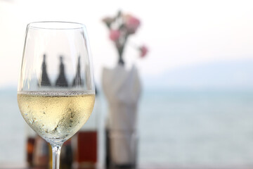glass of cold white wine on the summer seashore by the water, relaxing by the water, a gentle background of soft color