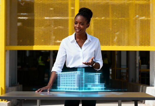 Female architect presenting a holographic 3D model of a building. Professional woman using futuristic augmented reality technology for a construction project