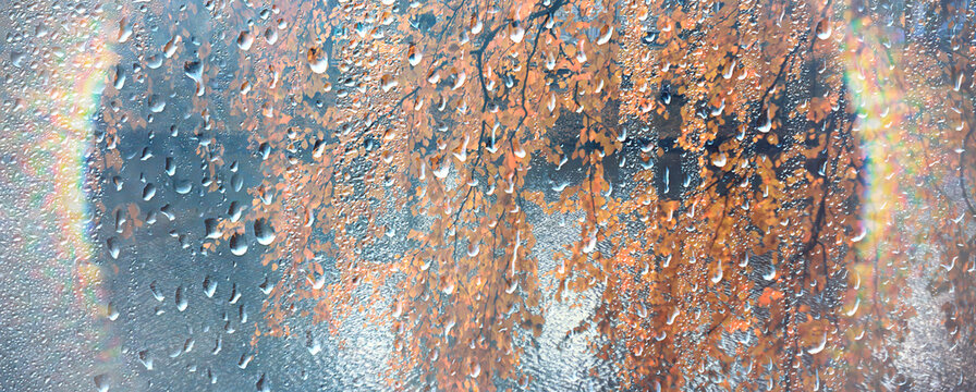 Raindrops on window glass background sun rays after rain, horizontal long design