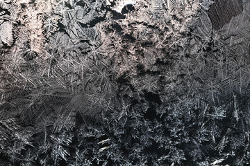 Ice crystals freezing on a black background, abstract winter photo surface