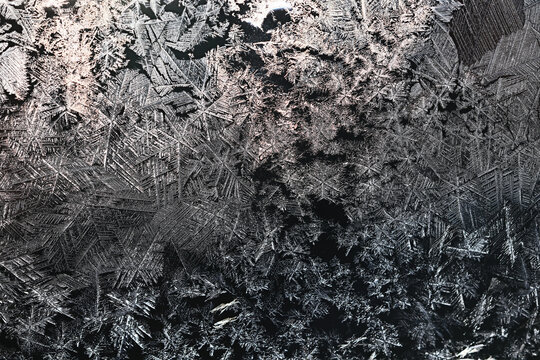 Ice crystals freezing on a black background, abstract winter photo surface