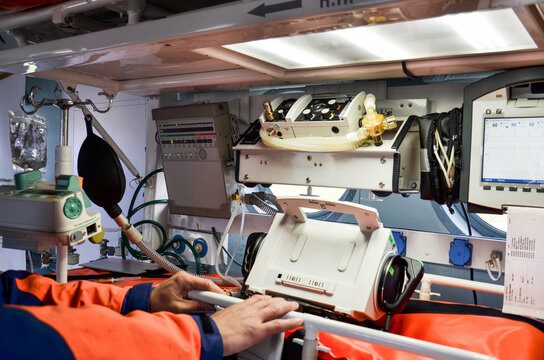 Medical professional operating advanced life support equipment in emergency vehicle, showcasing critical healthcare technology and teamwork in action - Powered by Adobe