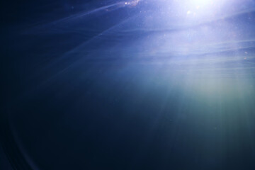 background rays of light under water, abstract pond in sunlight, nature backdrop underwater photography