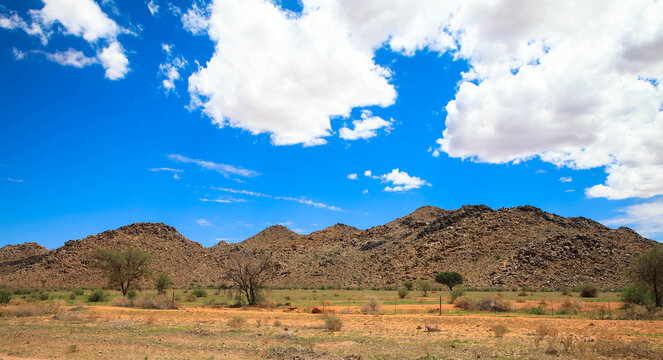 The Namib Desert is home to scattered brown stones and rugged rock formations, shaped over millennia by natural processes. Photographed on the C13 between Helmeringhausen and Aus, Namibia, Africa.