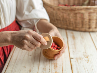 Woman is holding a wooden bowl with a lid on it