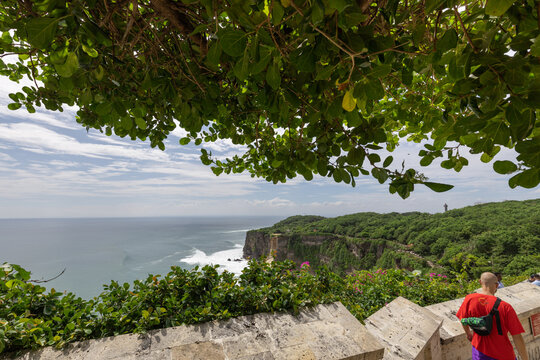 Man is walking on a path near the ocean