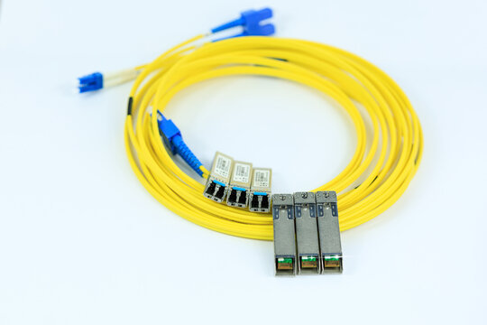 Yellow coiled fiber optic patch cord with blue connectors SFP modules are essential for high-speed data transmission over fiber optic networks.