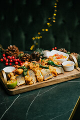 A wooden tray with a variety of food items on it, including shrimp, fish, and vegetables. The tray is placed on a green marble countertop