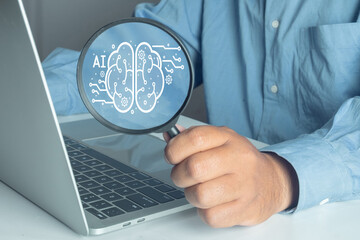 AI (Artificial Intelligence) analysis concept. Businessman holding magnifying glass focusing on virtual brain icon. Machine learning, data research, and technology innovation.