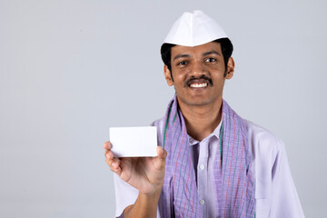 Portrait of Rural Indian middle class marathi man  Showing Aadhar card, debit card, voter id and farmer card while standing and looking in front of the camera against studio background 