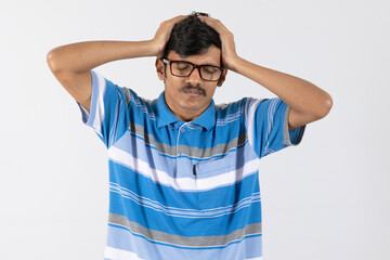 Indian young man suffering from headache desperate, stressed pain and migraine. Hands on head...
