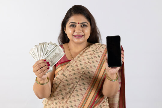 Indian happy young traditional woman holding indian rupees and smartphone empty mockup screen on white background