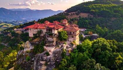 Obraz premium Ancient structure perched on cliff, surrounded by green trees and mountains
