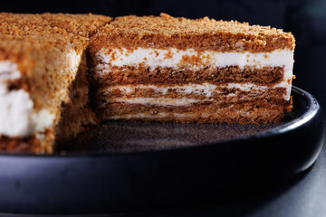 Layered Crumb Cake With Cream Filling On Dark Plate