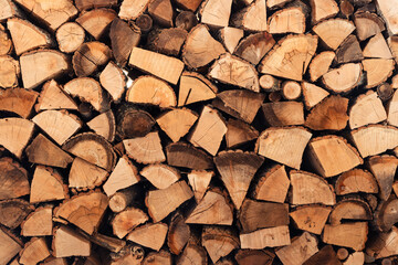 Stacked firewood pile creating abstract wood texture background