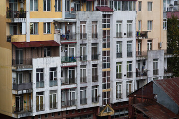 Colorful residential building with balconies and worn facade in Batumi, Georgia. Urban city housing architecture showing aging structure, everyday life, and apartment exterior detail.