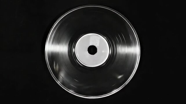 A record is spinning on a turntable. The record is silver and has a white circle in the center