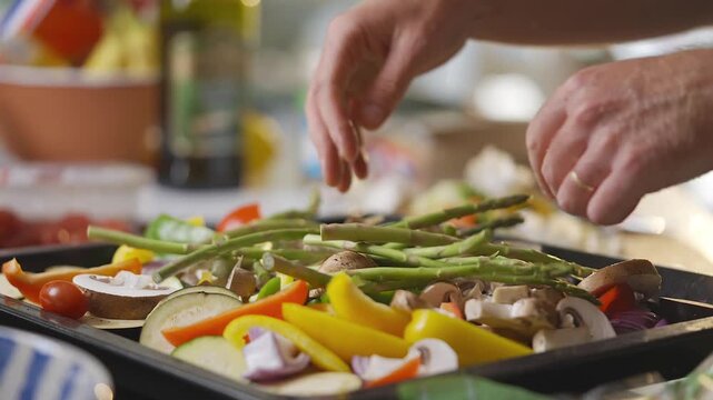 A person is holding a bunch of asparagus and putting them in a plastic bag. Concept of healthy eating and preparation for a meal