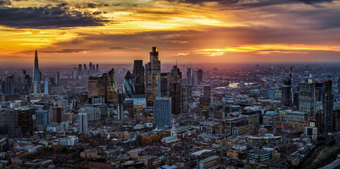 Panoramic aerial view of the London, England, skyline from south to the north with City skyscrapers and Westminster in the background during a golden sunset
