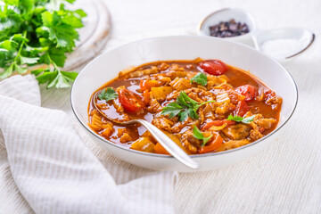 Spicy tripe soup made of beef with cabbage, red peppers and tomatoes