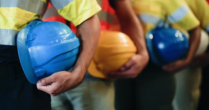 Hands, row and people with helmet for warehouse safety, site inspection and industry protocol. Line, employees and waiting with hard hat for quality control, workplace compliance and maintenance ppe