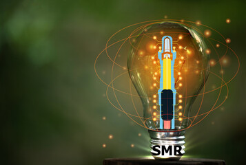 SMR text on light bulb and small nuclear power plant icon on natural background.