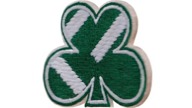 Close up of a green shamrock emblem with white diagonal stripes