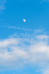 Waxing Gibbous Moon in Daytime Sky with Scattered Clouds