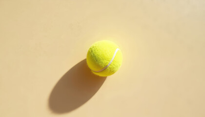 Bright yellow fuzzy tennis ball on yellow court surface. Ball casts shadow from bright light. Sports equipment for athletic training. Perfect for fitness related articles sport online store visuals.