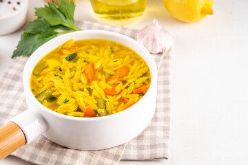 Tasty Italian Penicillin Soup, autumn winter immunity booster chicken vegetables orzo soup. Traditional european comfort food with ingredients for cooking on white table