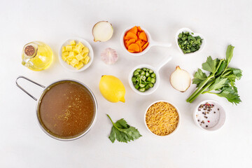 Tasty Italian Penicillin Soup, autumn winter immunity booster chicken vegetables orzo soup. Traditional european comfort food with ingredients for cooking on white table
