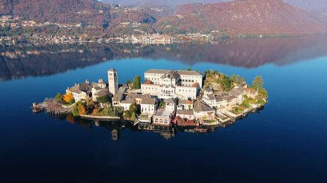Aerial view of Isola San Giulio island, a jewel amidst tranquil waters, revealing its historic buildings and serene beauty, Isola San Giulio, Piemonte, Italy.