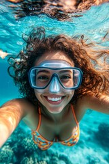 Fototapeta premium A pretty and sexy happy asian young woman with long hair with a happy face snorkeling among the corals. A dense school of silver fish swims next to her. Bright commercial style image.