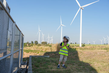 Children are running on a natural energy farm such as windmills and electricity.