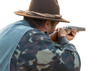 Hunter man in camouflage with a gun during the hunt in search of wild birds or game.