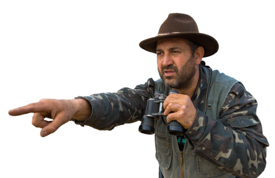 A hunter with a gun in his hands in hunting clothes in the autumn forest in search of a trophy. A man stands with weapons and hunting dogs tracking down the game.